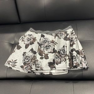 Floral silver skirt; undershorts present; brand: Justice; size 14